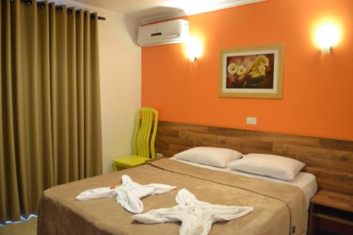 a hotel room with two beds with towels on them at Pousada Beija Flores in Porto De Galinhas