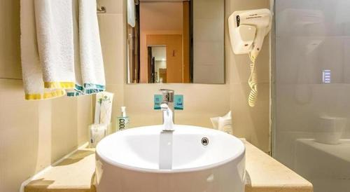 Un baño con un lavabo blanco y un espejo. en City Comfort Inn Nanning Wuming, en Wuming