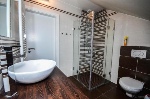 Apartman Masne kramy في تريبون: حمام مع حوض استحمام أبيض كبير ومرحاض