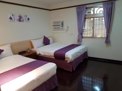 Cette chambre comprend 2 lits et une fenêtre. dans l'établissement Hua Luo Mi No. 35, à Hengchun Old Town