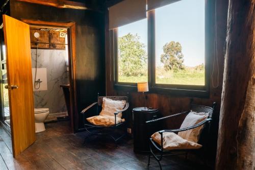 a bathroom with two chairs and a toilet at Cabañas en el Bosque a 5 minutos del mar - Estancia CH in Punta del Este