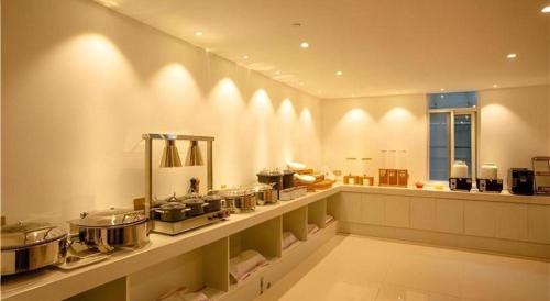 a kitchen with a counter with many pots and pans at Borrman Hotel Huaian Suning Plaza Huaihai West Road in Huai'an