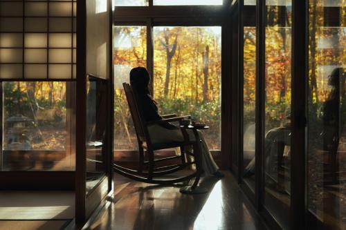 a rocking chair in a room with a window at 野荘 刂 -Yasou Ritto- in Sapporo