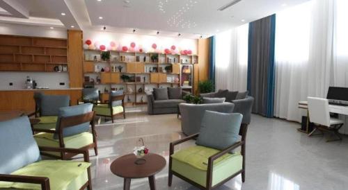 een lobby met banken en stoelen in een kamer bij GreenTree Inn Heze Shan County New Bus Station in Shan