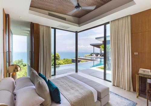 a bedroom with a large bed and a view of the ocean at Villa Raku in Koh Samui 