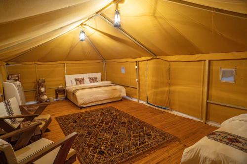 a room with a bed in a tent at Desert Vibes Camp in Bidiyah