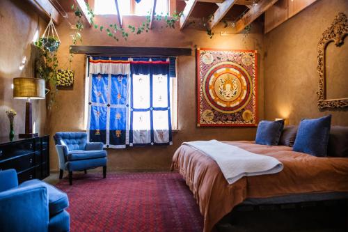 a bedroom with a bed and a chair and a window at CASA DE COUGLETTA - Artist retreat, stunning views in Santa Fe