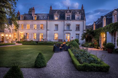 a man sitting on a couch in front of a house at Le Clos d'Amboise in Amboise