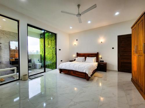 a bedroom with a bed and a sliding glass door at The Green Homestay - Galle in Galle