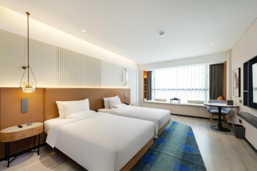 Ένα ή περισσότερα κρεβάτια σε δωμάτιο στο Grand Mercure Guangzhou Baiyun