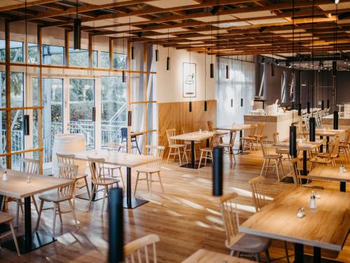 a restaurant with tables and chairs and windows at ibis Styles Graz Messe in Graz