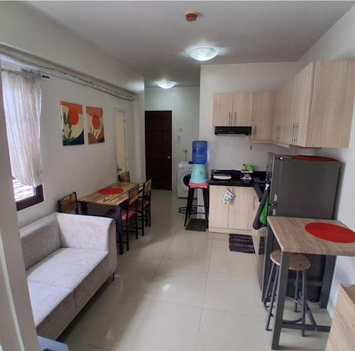 a living room with a couch and a table and a kitchen at Brookridge Suites in Cebu City
