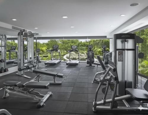 einen Fitnessraum mit mehreren Laufbändern und Maschinen in der Unterkunft Sky residences - Plage de Pattaya Pratamnak Moderne in Pattaya South