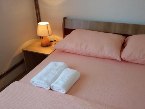 a bed with two white towels on top of it at Apartment Una Strbacki Buk in Kulen Vakuf