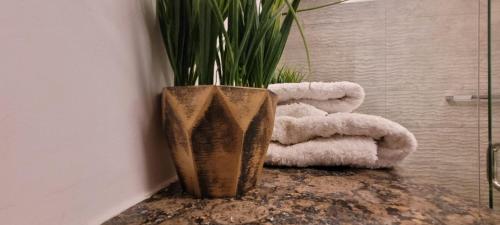 a vase with a plant in it next to towels at Goldcrest Luxury Apartments in Lahore