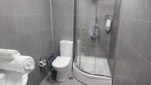 a bathroom with a shower with a toilet and a sink at Baku Khatai Central Hotel in Baku