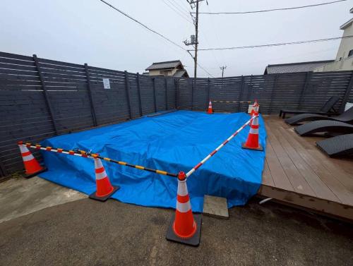 KujukuriにあるThe No.10 Sunrise Beach 九十九里のオレンジ色のコーンと青い防水シートが敷かれたバスケットボールコート