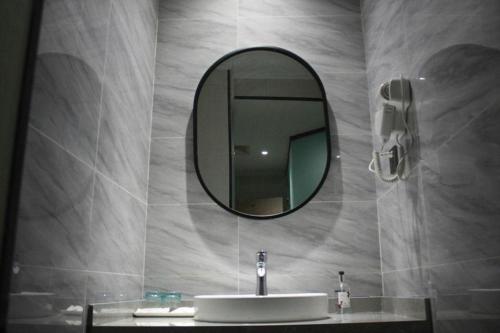 a bathroom with a sink and a mirror at Borrman Hotel Ji'an Railway Station Jinggangshan University in Ji'an