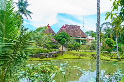 ein Haus mit einem Teich davor in der Unterkunft Hotel Deli River and Restaurant Omlandia in Medan