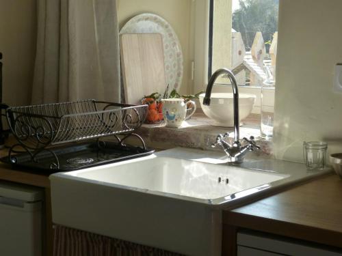 eine Küchentheke mit Spüle und Fenster in der Unterkunft La maison d'Alcime in Plumergat