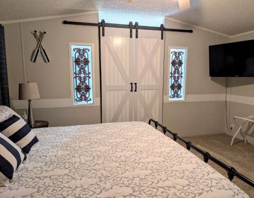 a bedroom with a bed and a sliding barn door at Rough River Lake Cabin Fishing in Fentress McMahan
