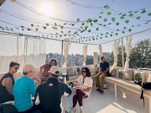 a group of people sitting on the roof of a building at Turtle Hostel Udaipur- 10 mtr from Lake in Udaipur