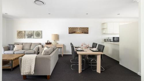 a living room with a couch and a table at Oaks Pacific Blue Pool spa more in complex in Salamander Bay
