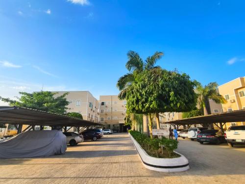 a parking lot with palm trees and cars parked at Jun Yue 9 Hotel Kano in Kano