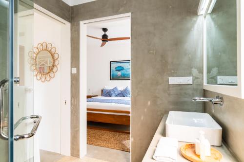 a bathroom with a sink and a bedroom with a bed at Ginger Palm Villa in Hiriketiya