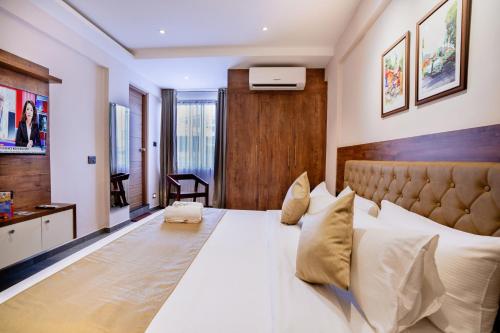 a bedroom with a large bed with white sheets and pillows at Seaking Suites in Ernakulam