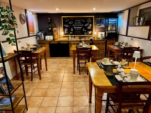 un restaurante con mesas de madera y una pizarra en la pared en Les Vieilles Digues, en Beauvoir
