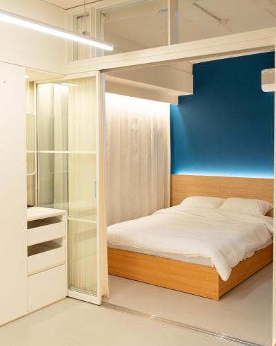a bedroom with a bed and a blue wall at 부사노바 in Busan
