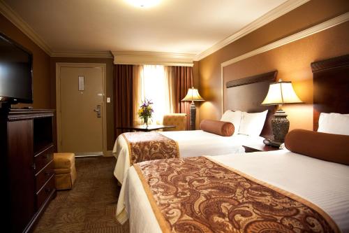 a hotel room with two beds and a television at Best Western Plus French Quarter Courtyard Hotel in New Orleans