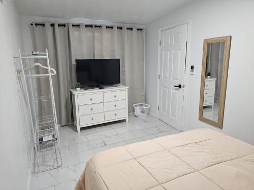 a bedroom with a television and a dresser with a mirror at Apartamento Acogedor con Estilo in Tampa