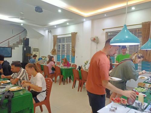 un grupo de personas comiendo comida en un restaurante en catba island hotel, en Cat Ba