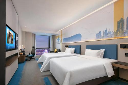 a hotel room with two beds and a flat screen tv at Hilton Garden Inn Nanchang Chaoyang Center in Nanchang