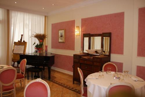jadalnia ze stołem, lustrem i fortepianem w obiekcie Grand Hotel degli Angeli w mieście San Giovanni Rotondo