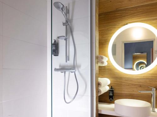 a bathroom with a shower with a sink and a mirror at ibis Styles Les Houches Chamonix in Les Houches