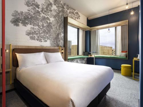 a bedroom with a large bed and a large window at ibis Styles Copenhagen Orestad in Copenhagen