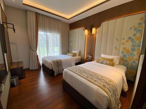 een hotelkamer met twee bedden en een raam bij Putri Duyung Ancol in Jakarta