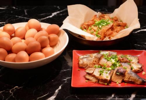 une table avec des assiettes de nourriture contenant des œufs et de la viande dans l'établissement ibis Styles Bangkok Sukhumvit Phra Khanong, à Bangkok
