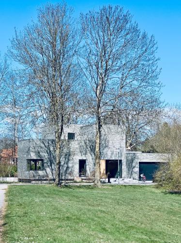 a gray house with two trees in front of it at Luxury Villa With Garden Sauna, near Aarhus City in Højbjerg
