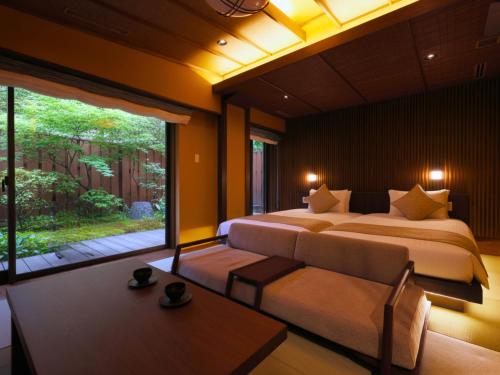 Un dormitorio con dos camas y una gran ventana. en 箱根薫風, en Hakone