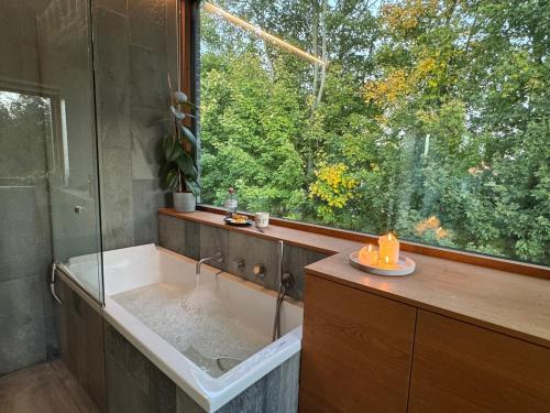 a bathroom with a tub and a large window at Luxury Villa With Garden Sauna, near Aarhus City in Højbjerg