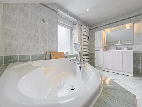 a large white bath tub in a bathroom at Grand Triplex 140m2 dans les Vosges in La Celle-sous-Gouzon