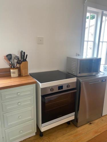 a kitchen with a stove and a microwave at Russell Waterfront Historic Cottage in Russell