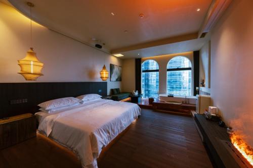 a bedroom with a large bed and a fireplace at Shanheli Mediterranean Seaside Resort Homestay East Coast Branch in Ma Yu