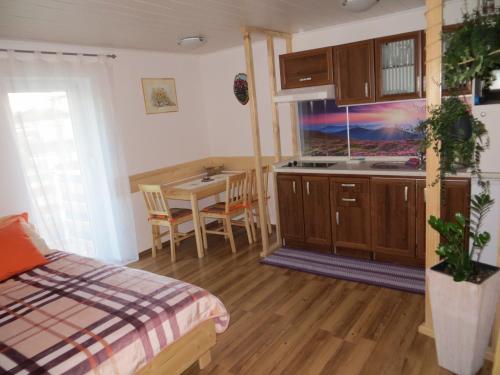a bedroom with a bed and a kitchen with a table at Studio Lipa in Maribor
