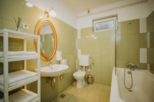 a bathroom with a sink and a toilet and a tub at Kossuth Apartments in Gheorgheni