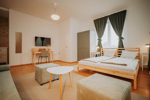 a bedroom with a bed and a table and a couch at Kossuth Apartments in Gheorgheni